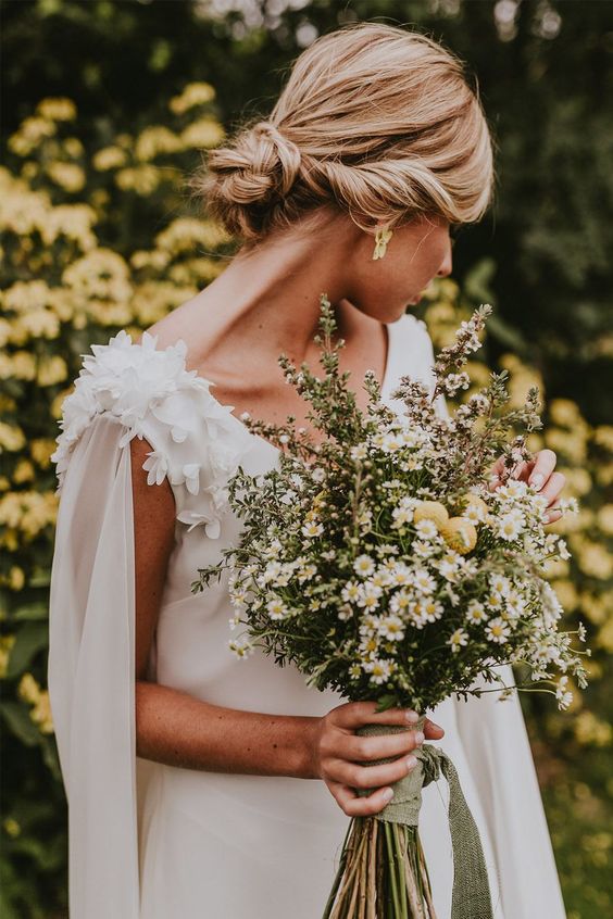 a cool boho wedding bouquet for a spring or summer bride, with chamomiles and billy balls is a lovely idea