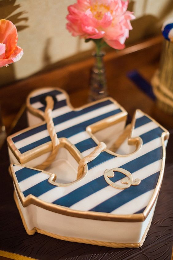 a creative nautical wedding cake shaped as a striped anchor with gold rope is a lovely idea to rock and its look in unique