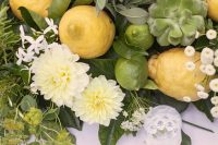 a creative wedding centerpiece of white blooms, greenery, lemons, succulents and limes is an awesome idea for an Italian wedding