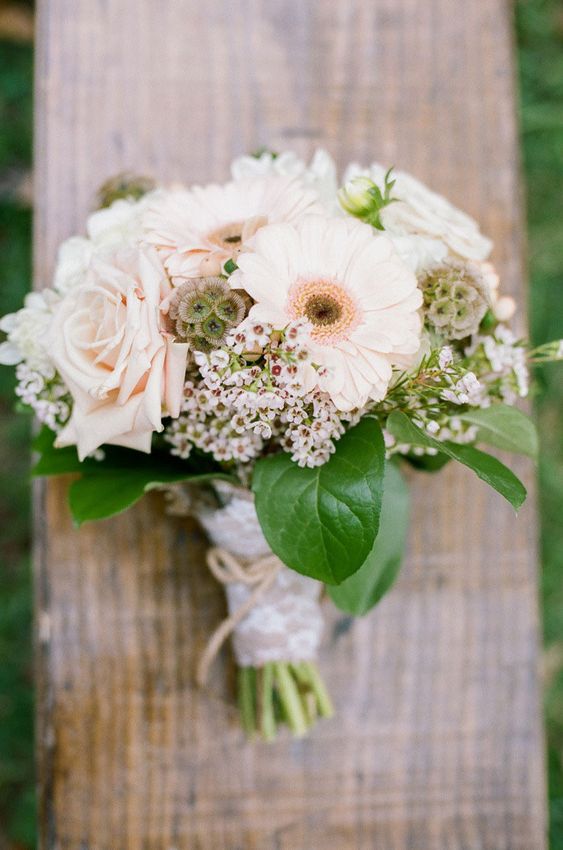 a delicate neutral wedding bouquet of blush gerberas and roses, seed pods and waxflower and greenery for spring