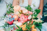 a fantastic wedding bouquet of peachy and orange blooms, pale pink tulips, yellow blooms and blue ones, greenery