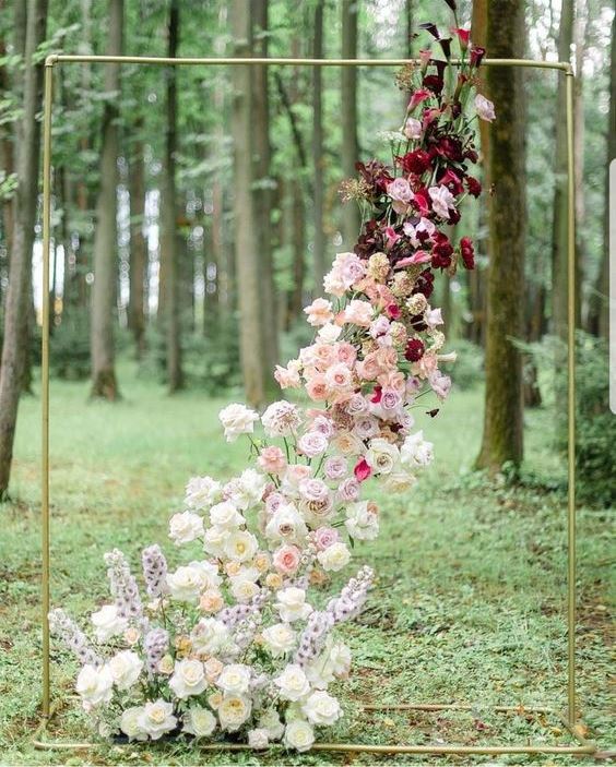 a gold wedding arch with a floral installation with an ombre effect from white to burgundy looks spectacular