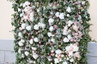 a gorgeous botanical wedding backdrop of greenery, white, mauve and pink blooms and lots of foliage plus petals on the ground