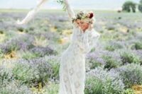 a lace wedding dress with long sleeves, a floral crown and a messy bouquet create a lovely and chic spring bridal look