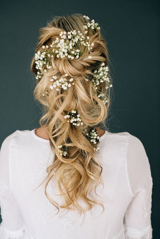 a loose braided and wavy half updo with baby's breath tucked in looks very boho-like and very springy