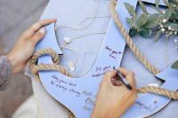 a lovely blue anchor plaque as a wedding guest book, with rope and greenery is a cool solution for a coastal wedding