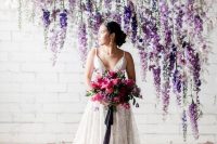 a lush floral wedding backdrop with an ombre effect from blush and mauve to lavender and purple hanging over the space