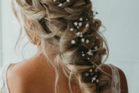 a mermaid braid with a braided halo and some baby’s breath tucked in, it’s a cool idea for a spring boho bride