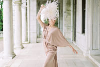 a modern ballet wedding dress in dusty pink, with a deep neckline, wide sleeves and a draped skirt