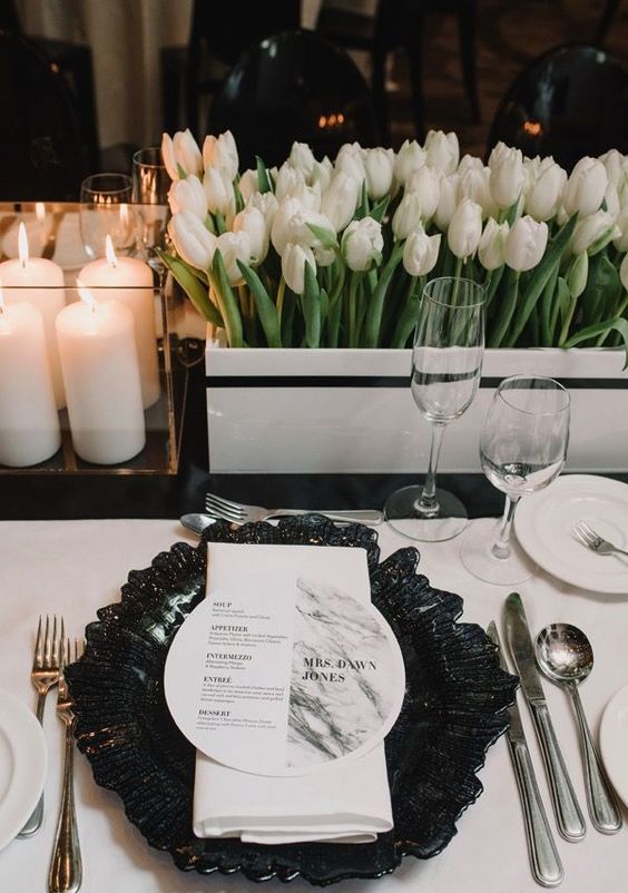 a modern wedding centerpiece of a white striped box and white tulips plus pilalr candles is a great idea for a modern wedding