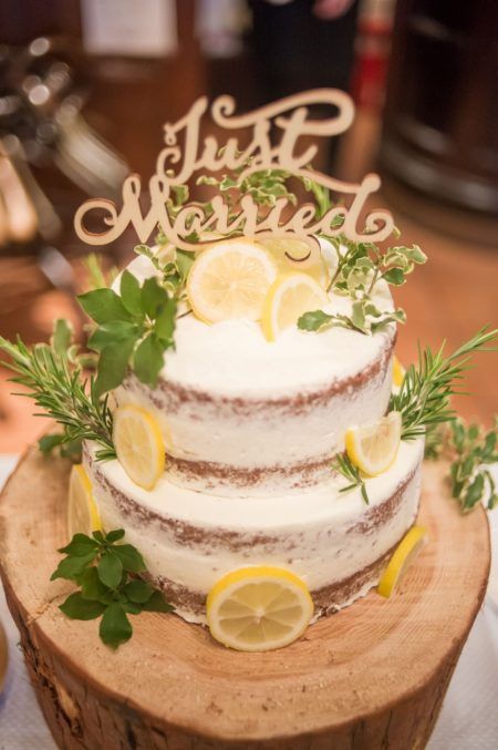 a naekd wedding cake with herbs, lemon slices and a calligraphy cake topper is a fantastic idea for spring or summer