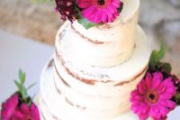 a naked wedding cake topped with hot pink gerberas and greenery is a bold and cool solution for a bright wedding