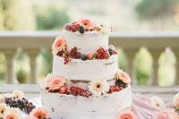 a naked wedding cake topped with white and blush gerberas, berries is a gorgeous idea for a summer wedding