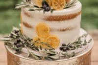 a naked wedding cake with herbs, berries and lemon slices is an amazing idea for a spring or summer wedding