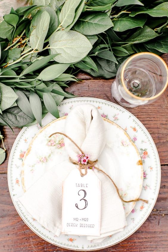 a neutral napkin with twine and blooms is a lovely rustic touch to the space, it's a simple idea to substitute a usual napkin ring with twine