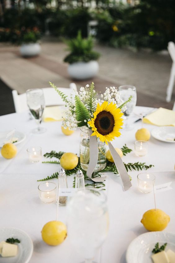 a neutral wedding tablescape spruced up with bold touches of lemons and sunflowers looks amazing and inviting