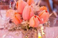 a pretty and easy wedding centerpiece of a vase with pale greenery, peachy tulips and some dried herbs is amazing