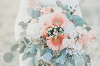 a pretty wedding bouquet of white hydrangeas, blush garden roses and coral gerberas plus greenery and berries