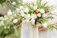 a quirky wedding bouquet composed of white tulips with leaves and twigs is a unique solution for a fairytale bride