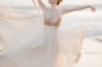 a romantic rose gold wedding dress with a sleeveless sequin bodice and a deep neckline plus a layered skirt
