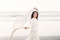 a romantic white lace dress and a white chunky knit sweater for a winter coastal bride