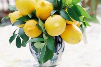 a simple and bold wedding centerpiece of a blue printed vase with lemons and greenery can be repeated anytime