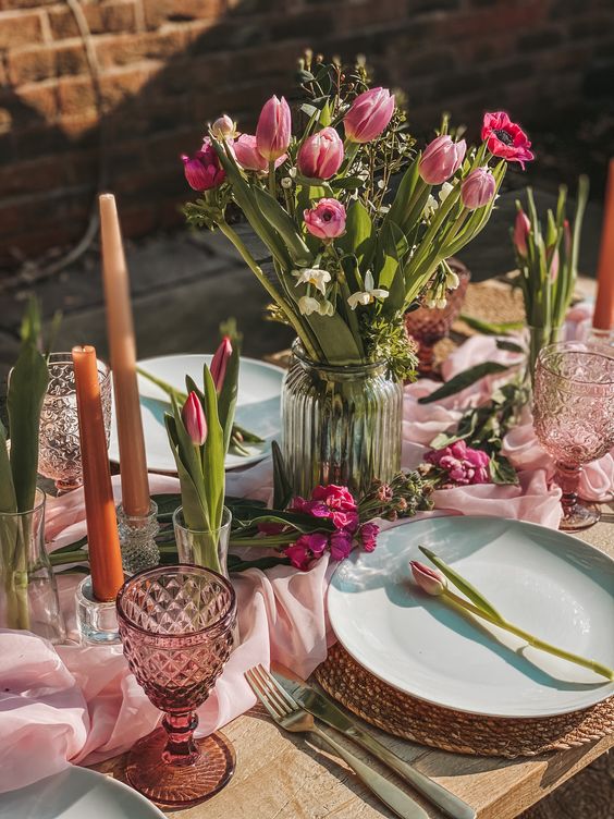 a simple and bold wedding centerpiece of a ribbed jar, pink tulips and white daffodils and greenery can be easily repeated
