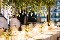 a small and cool overhead wedding installation of greenery and hanging white tulips is a lovely idea for a modern celebration