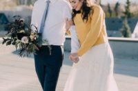 a sunny yellow sweater put on over a romantic lace wedding dress