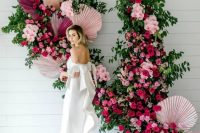 a super bold and lush wedding backdrop of greenery, pink, blush, fuchsia blooms and colorful fronds is just jaw-dropping