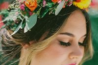 a super colorful floral crown with orange, pink, yellow blooms, lots of greenery for texture and some berries is amazing