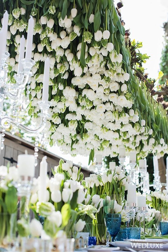 a super lush and bold overhead wedding installation made of white tulips is a fantastic idea for an elegant wedding