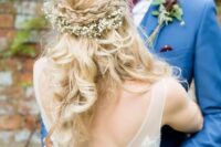 a wavy half updo with a double braided halo and baby’s breath looks sweet