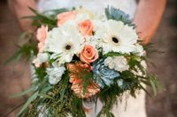a wedding bouquet of white gerberas, coral roses, blue blooms and greenery is a creative idea for a wedding