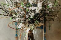 a whimsical boho spring wedding bouquet of blooming branches, greenery, willow and twigs is a lovely idea for a boho bride