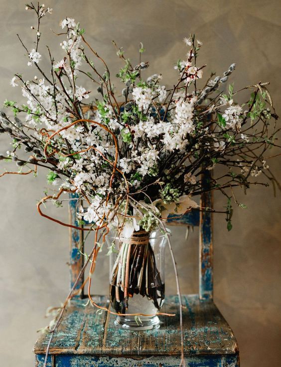 a whimsical boho spring wedding bouquet of blooming branches, greenery, willow and twigs is a lovely idea for a boho bride