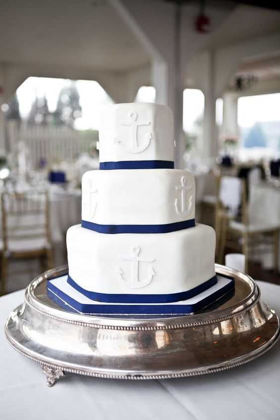 a white and navy hexagon-shaped wedding cake with anchors is a stylish idea for a seaside or nautical wedding