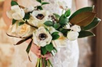 a white anemone wedding bouquet with magnolia leaves and greenery is a chic and non-traditional idea