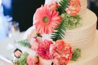 a white textural buttercream wedding cake with bold coral hydrangeas and gerberas, greeneyr for a bright summer wedding