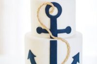 a white wedding cake with a navy anchor and gold rope is a stylish solution for a modern nautical wedding