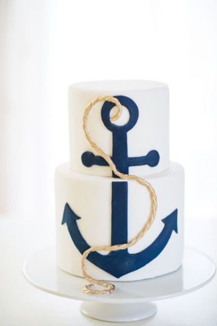 a white wedding cake with a navy anchor and gold rope is a stylish solution for a modern nautical wedding