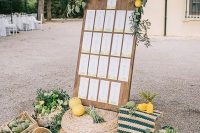 beautiful Italian-style wedding decor with jute poufs, a seating chart with greenery and lemons, crates and baskets with lemons