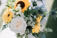 bold aisle chair decor with yellow gerberas, sunflowers, white roses and waxflower, greenery and thistles