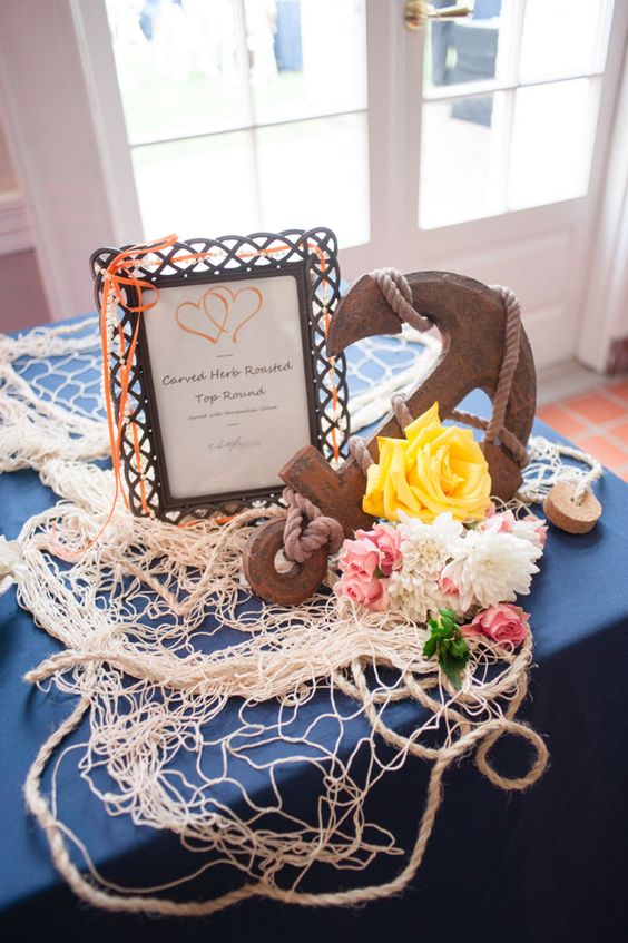 vintage nautical wedding decor with net, rope, a vintage anchor, a sign and some bold and neutral blooms is an amazing idea