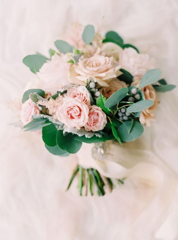 a delicate blush wedding bouquet of roses, astilbe, greenery and berries is a lovely and subtle wedding bouquet idea