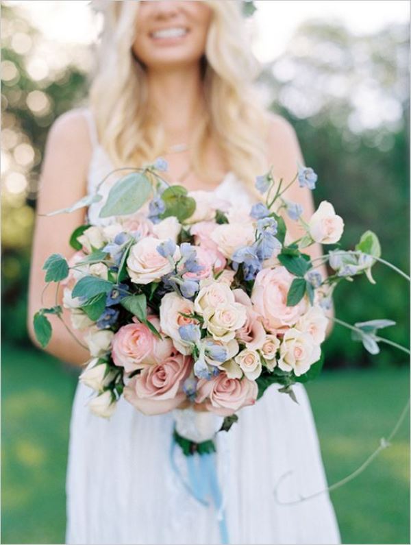 a pastel wedding bouquet of blush roses and pink blooms plus some greenery is a refined idea for a spring or summer wedding