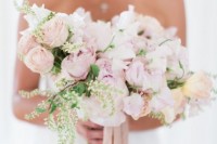 a sophisticated wedding bouquet of light pink and white blooms, greenery and long blush ribbons is a very beautiful accessory