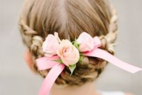 a braided low updo with pink roses and a small bow is a very cute and very girlish idea that will match many looks