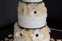 a bright white patterned wedding cake with white and blush blooms between the tiers is very bold