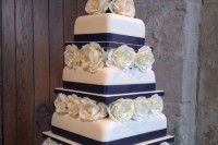 a bold contrasting wedding cake in white and navy and white roses between the tiers for a bold look